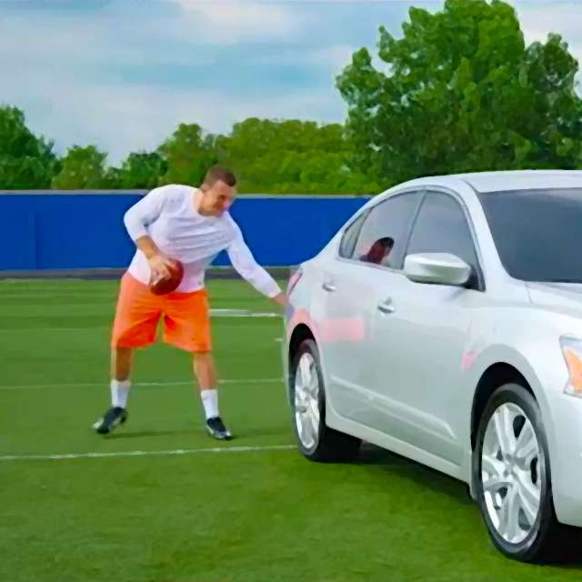 Johnny Manziel pats a Nissan Altima on the bumper