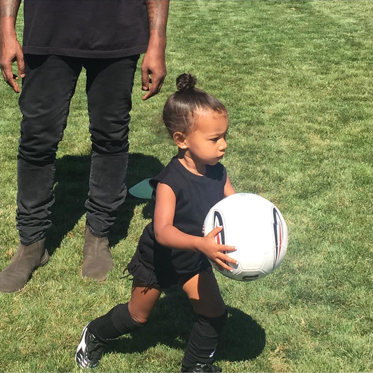 North West plays soccer in front of father Kanye West